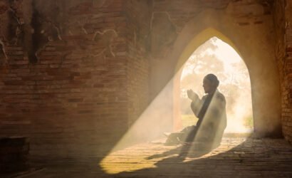 The silhouette of an Asian Muslim man, who is praying in a room
